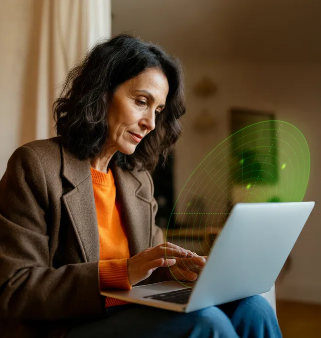 Woman using a laptop to secure accounts after an email breach.