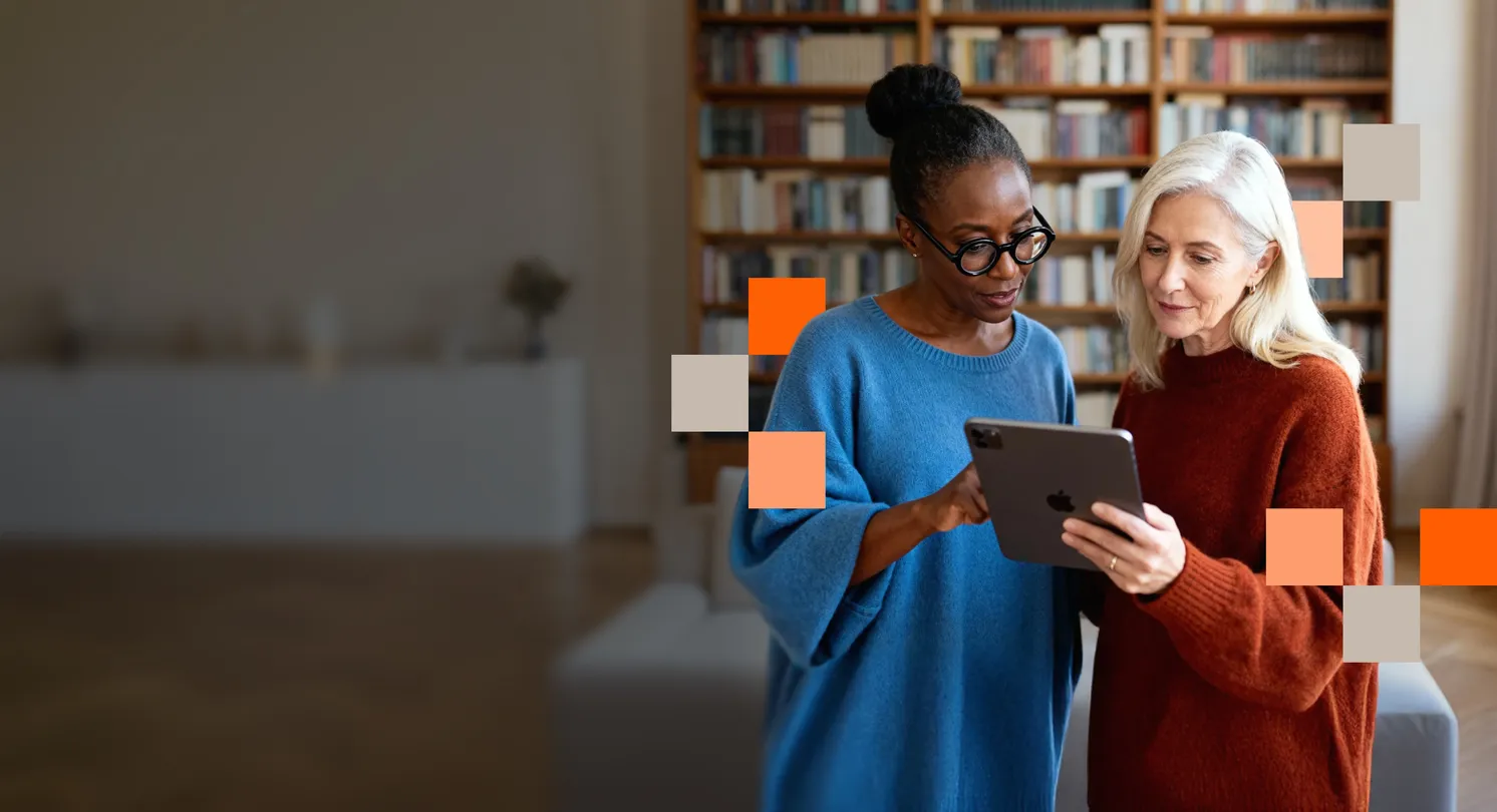 Two women using a tablet to check NordProtect cyberattack insurance benefits.
