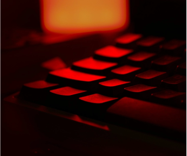 A computer keyboard in red light, symbolizing the risk of a cyberattack.