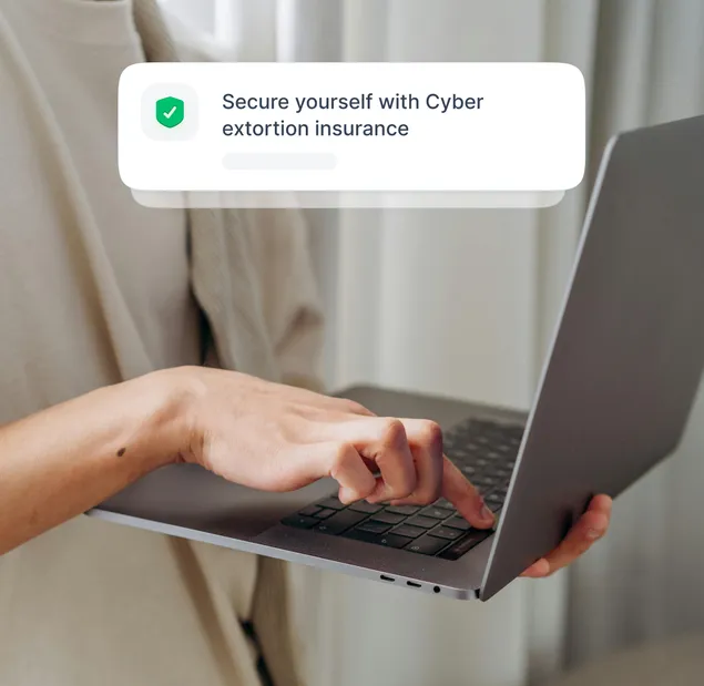 A person using a laptop to purchase NordProtect’s cyber extortion insurance.
