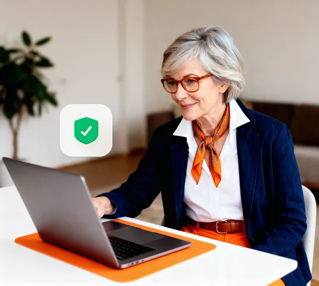 A woman using her laptop to review NordProtect insurance benefits for cyberattack, cyber extortion, and online fraud.
